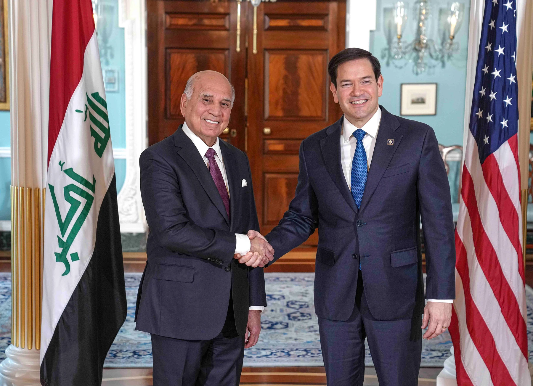 Iraqi and U.S. flags stand beside Fuad Hussein and Marco Rubio during their meeting at the U.S. Department of State in Washington, D.C., on April 25, 2025.