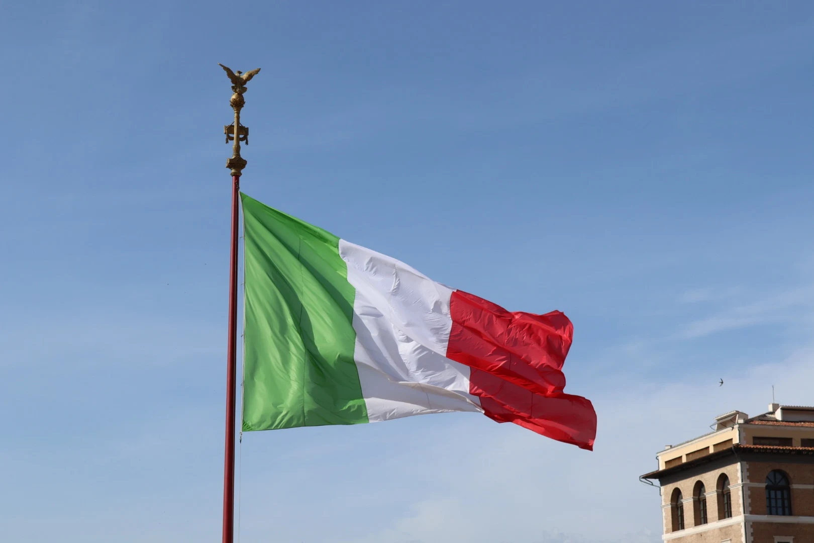 An Italian flag flies at the Vittoriano in Rome on April 21, 2025. The photographer’s full frame shows the green band attached to the staff and the red band at the free edge.